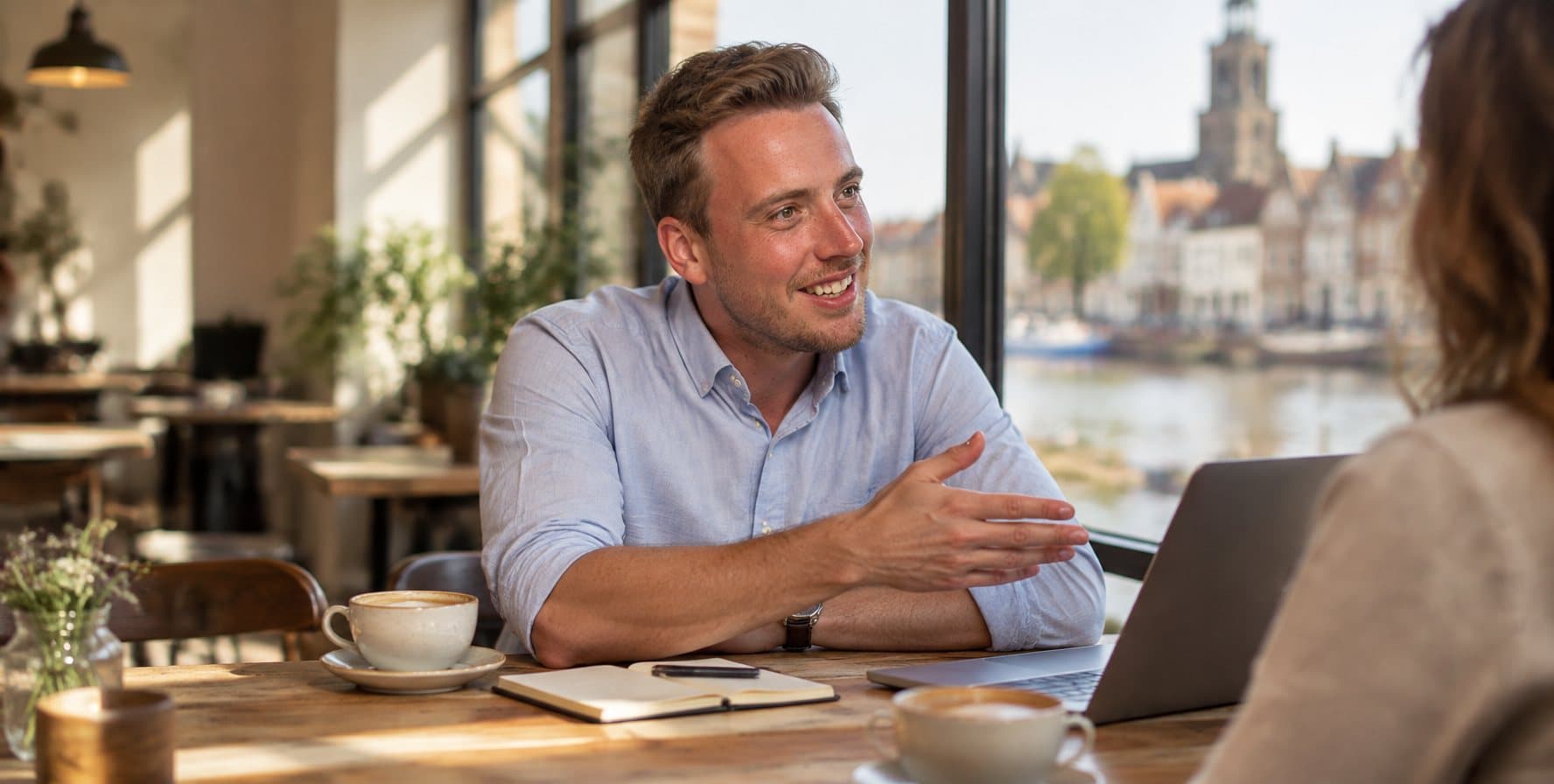 Jan-Wigbold aan tafel met een klant, de laptop open